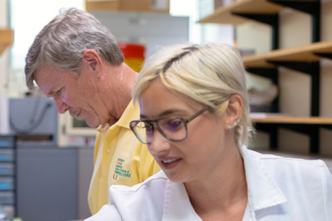Hansell and PhD student in lab
